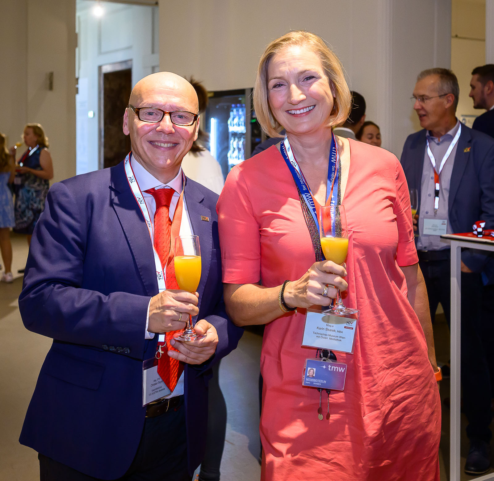 <br /> Herr und Dame lächeln und halten Sektgläser mit Orangensaft in den Händen.